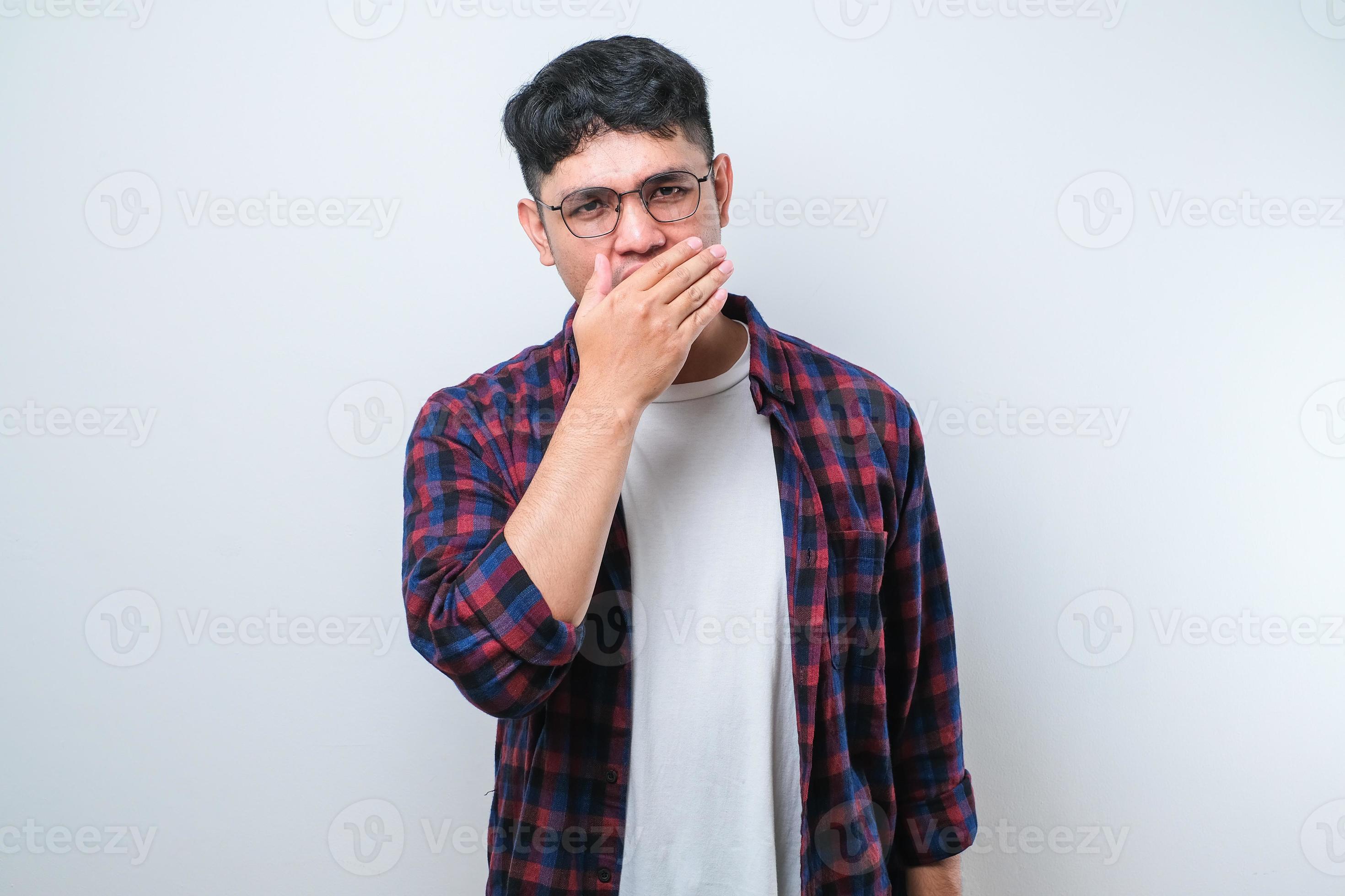 Young asian man smelling something stinky and disgusting, intolerable