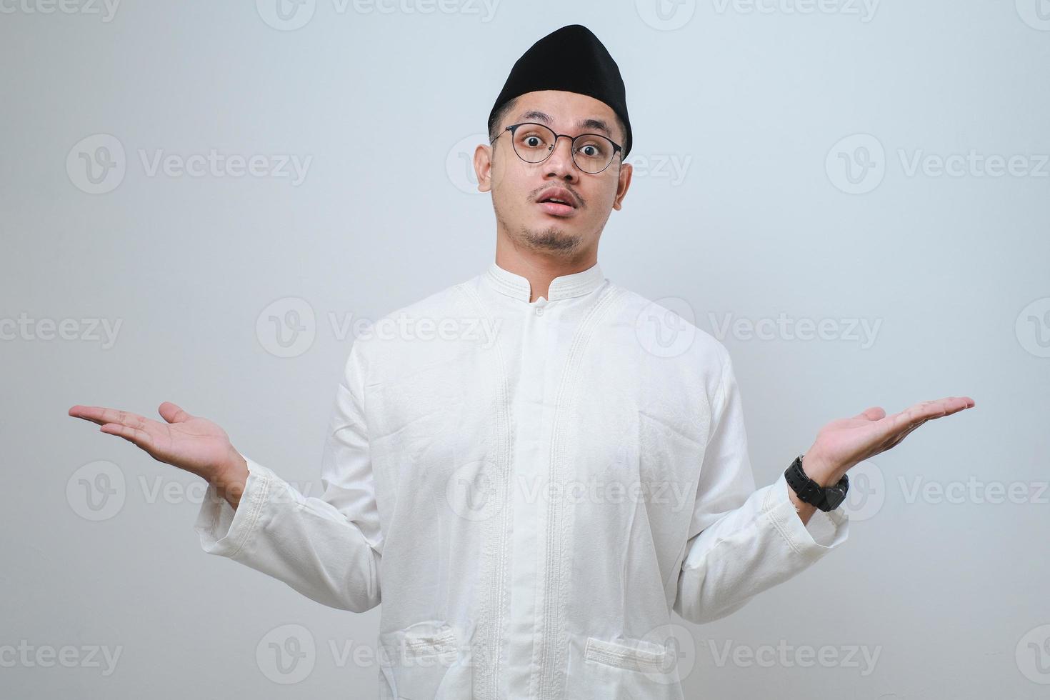 Asian muslim man raised arms and looking at camera with doubtful face. photo