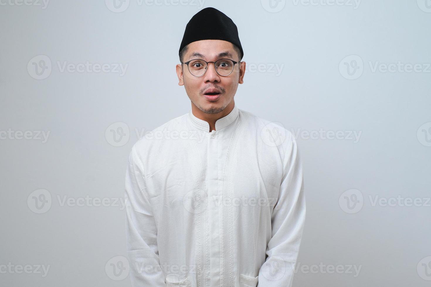 Asian muslim man shocked gesture can not believe of what he sees. Worried expression photo