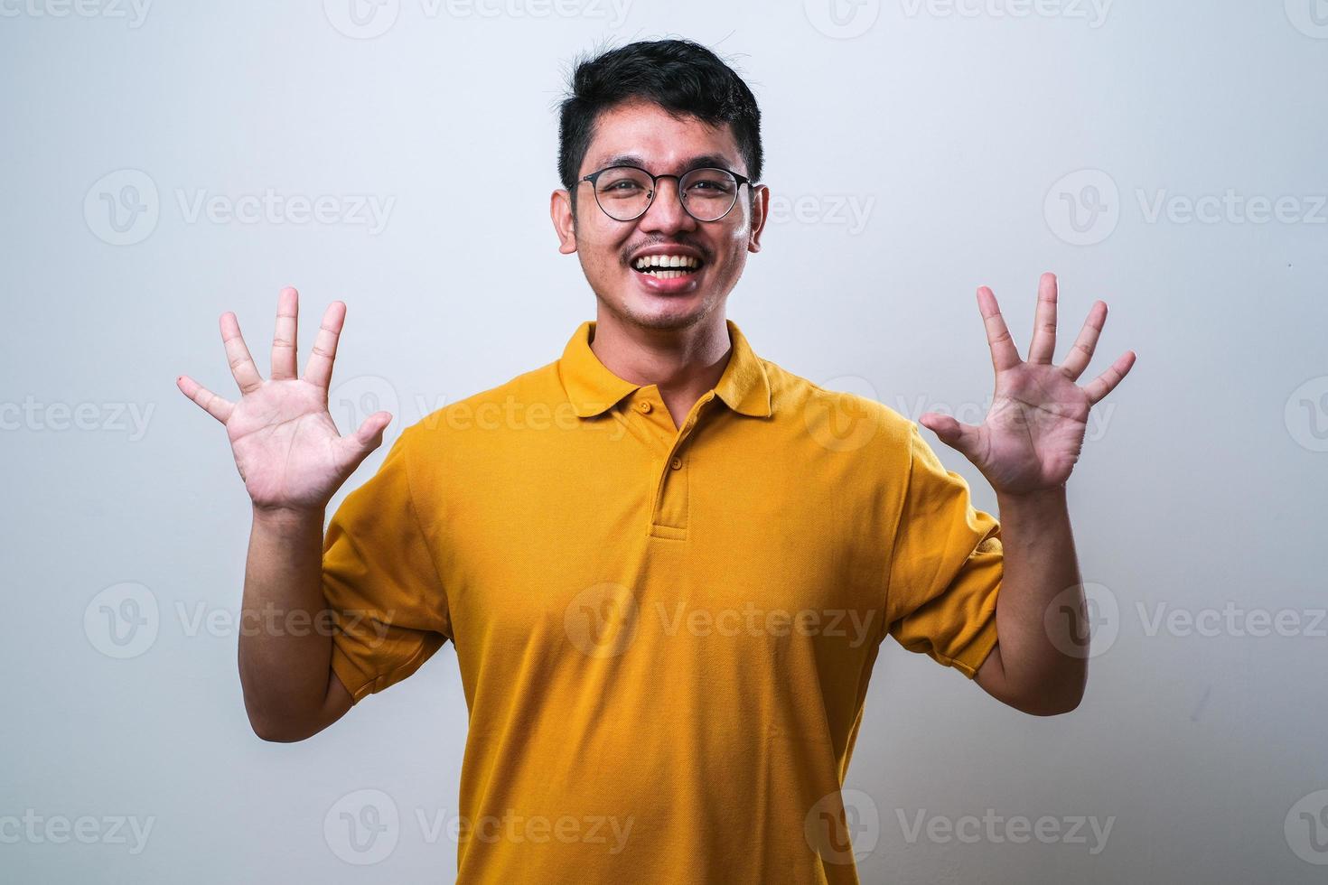 Asian young man showing and pointing up with fingers number ten photo