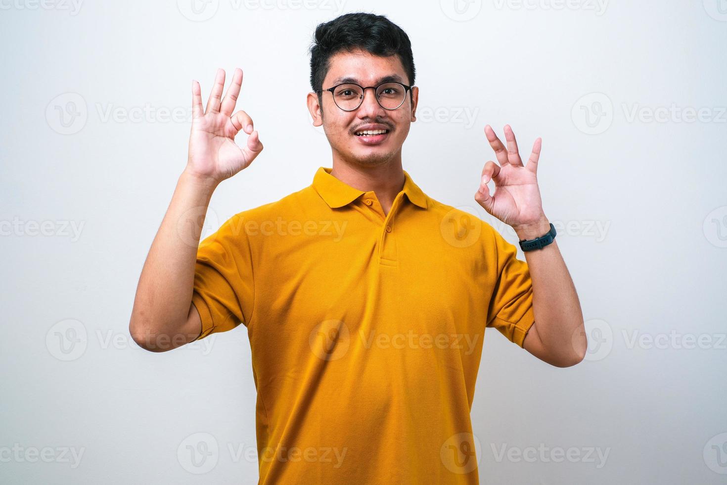 Adult Asian man showing excited face expression while giving two OK finger sign photo