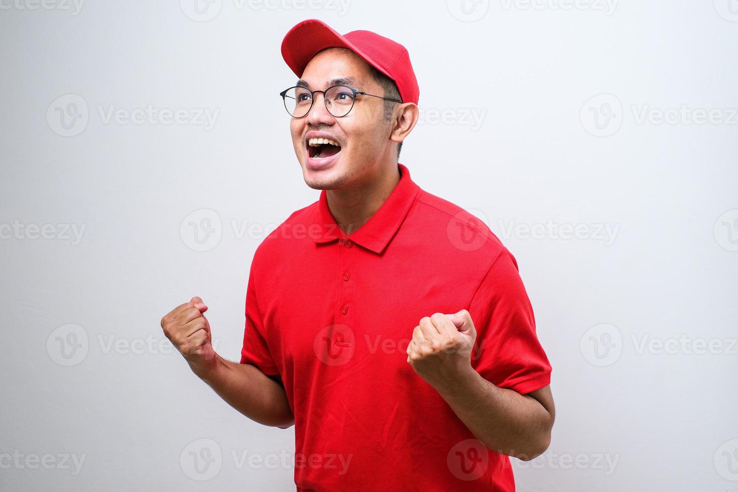 Asian delivery man very happy and excited doing winner gesture with arms raised, smiling and screaming for success. photo
