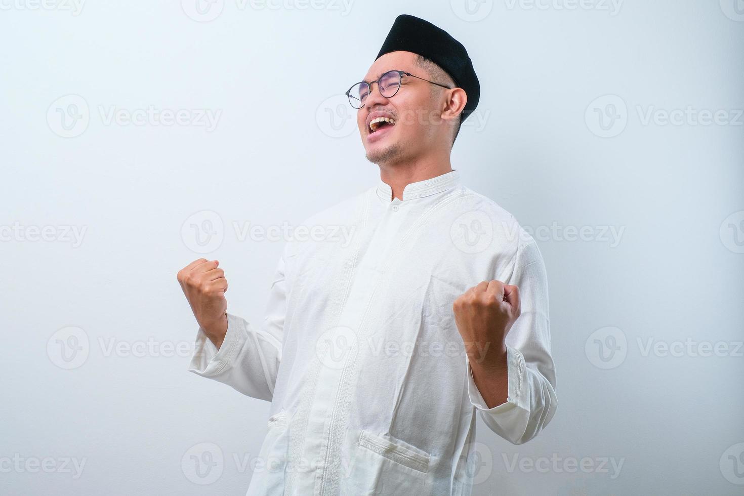 Successful happy muslim man screaming shouting and shows winning victory gesture photo