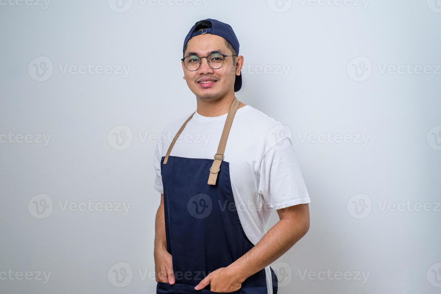 retrato de joven barista asiático sonriendo, usando delantal foto