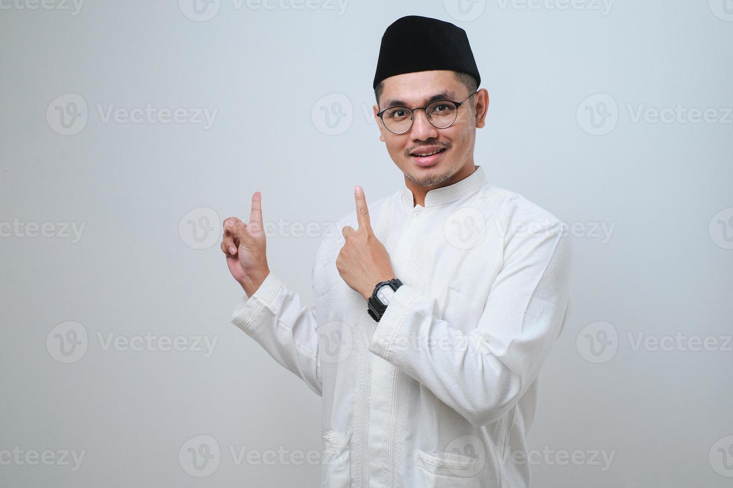 Asian muslim mas pointing something on his side with his both hand photo