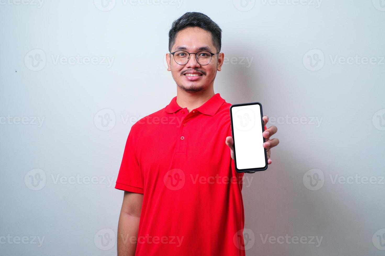Portrait of young young Asian man presenting smart phone mockup with happy cheerful expression photo