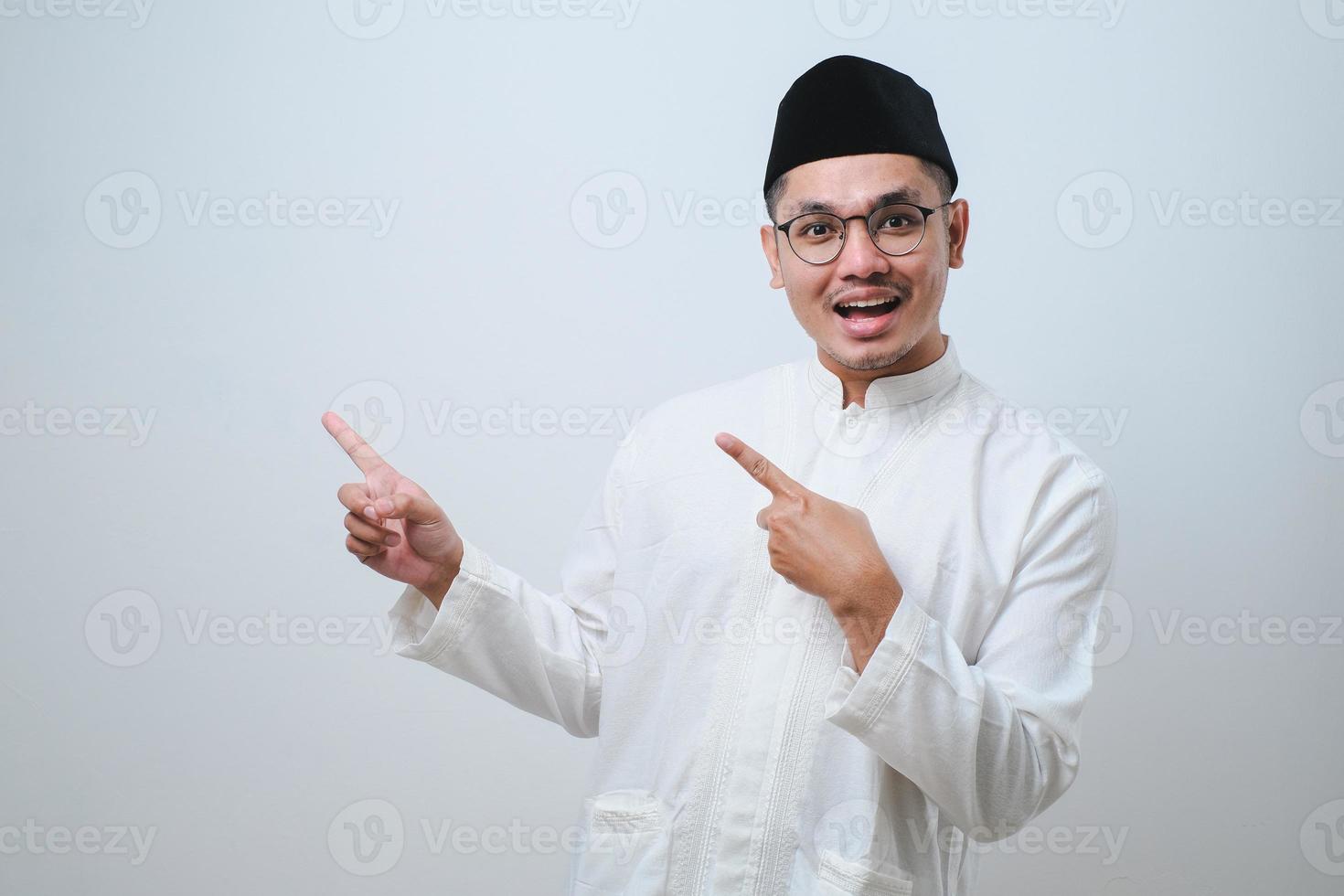 Asian muslim mas pointing something on his side with his both hand photo