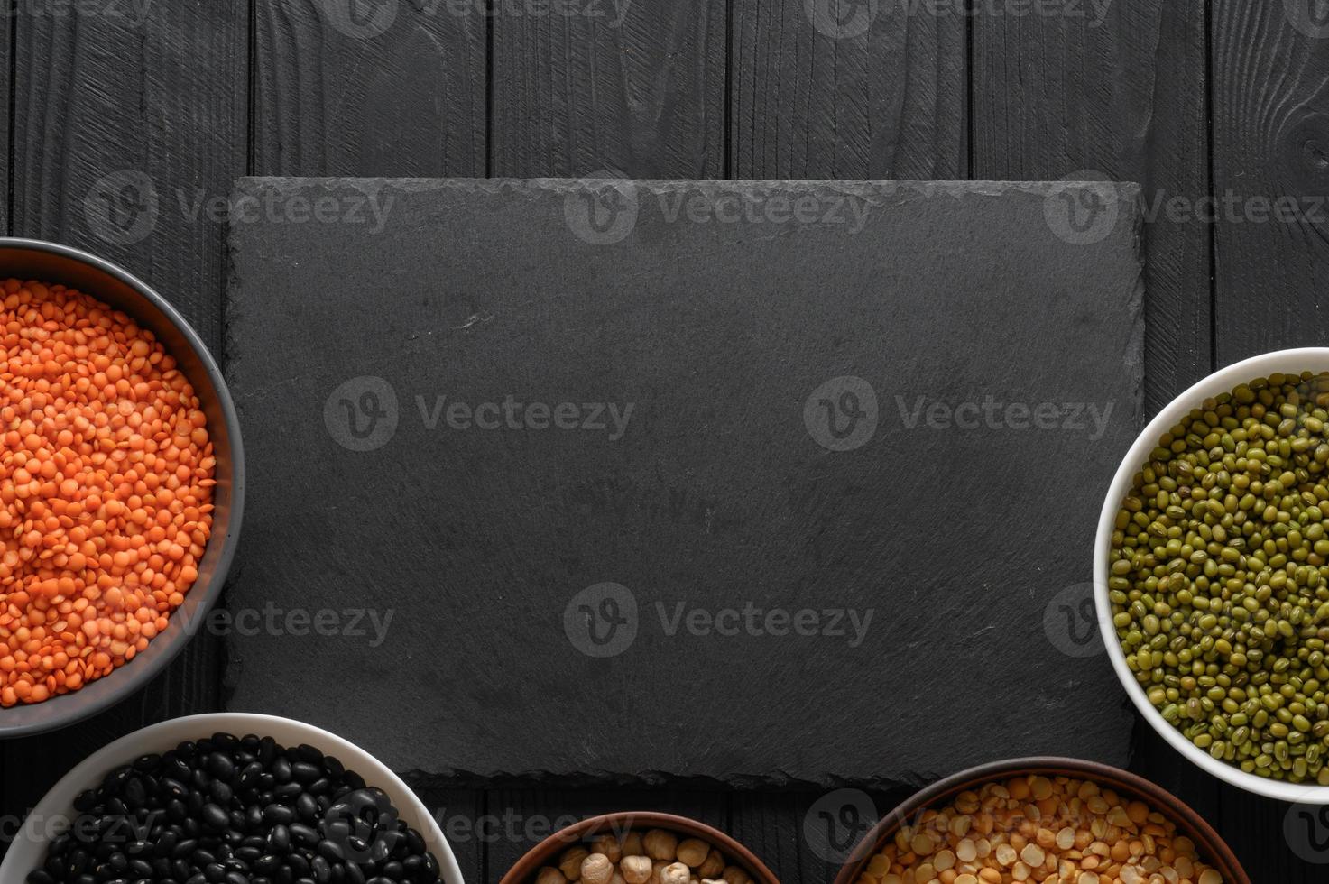 Legumes, overhead flat lay shot on a dark rustic wooden background with a place for text photo