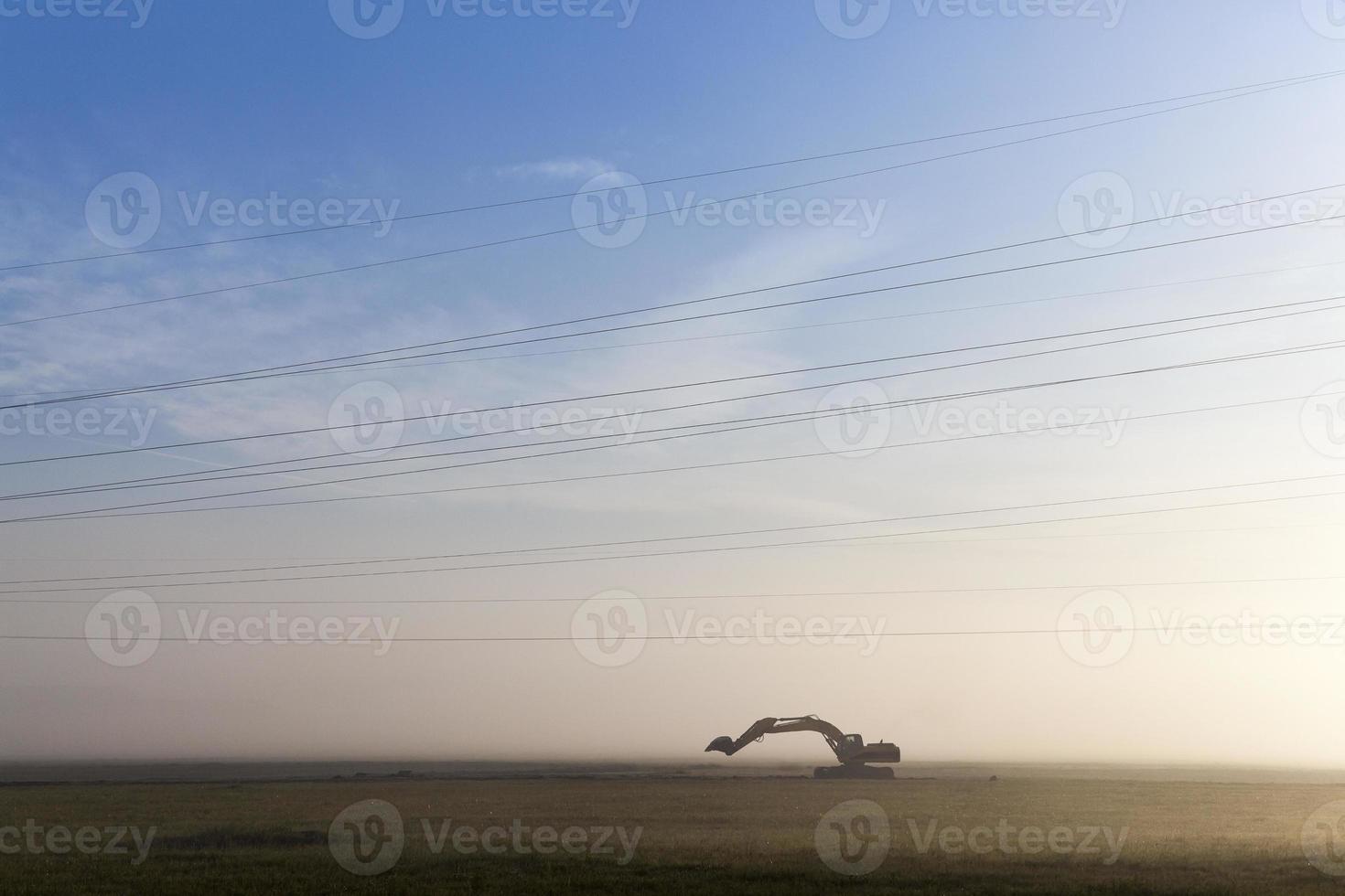 Excavator in a fog photo