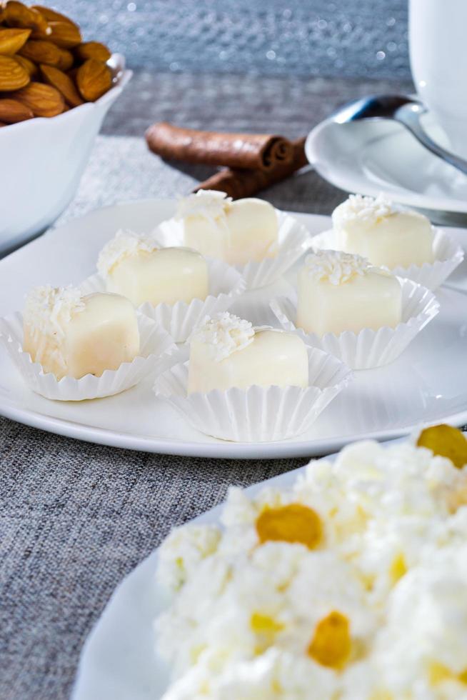 Chocolates in heart shaped white chocolate on the tablecloth photo