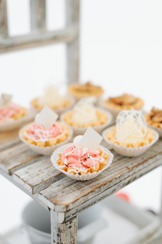 Variety of tasty appetizing sweet desserts with cream, berries and pastry, bakery and cakes on the grand wedding table at celebrate photo