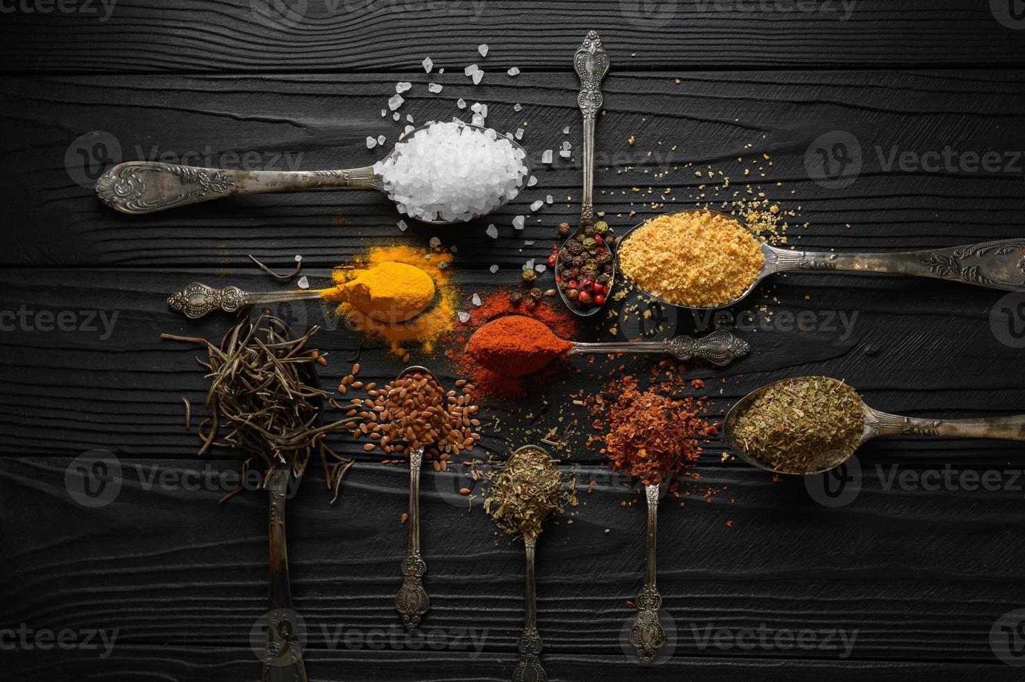 Colorful various herbs and spices for cooking on dark wooden rustic background photo