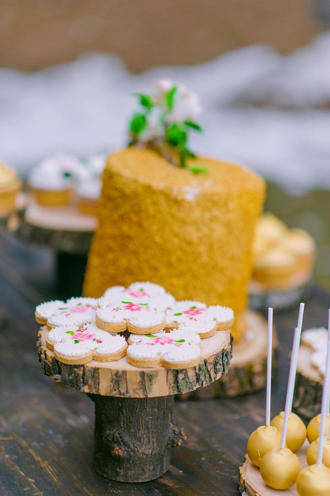 tortas en una mesa de madera para una barra de dulces de boda foto