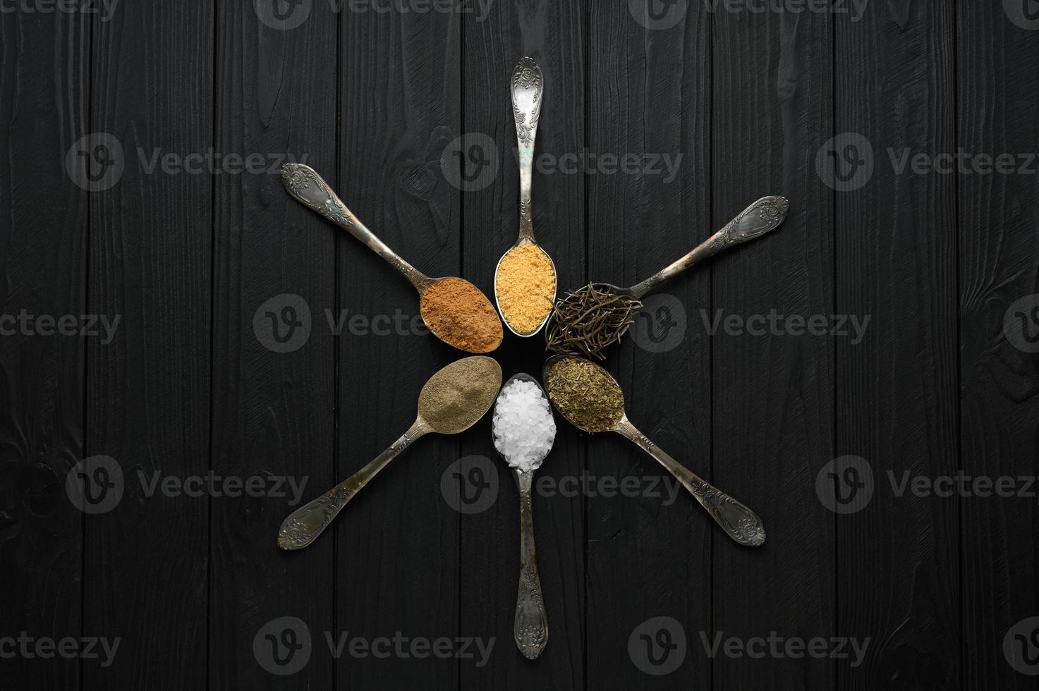 Colorful various herbs and spices for cooking on dark wooden rustic background photo