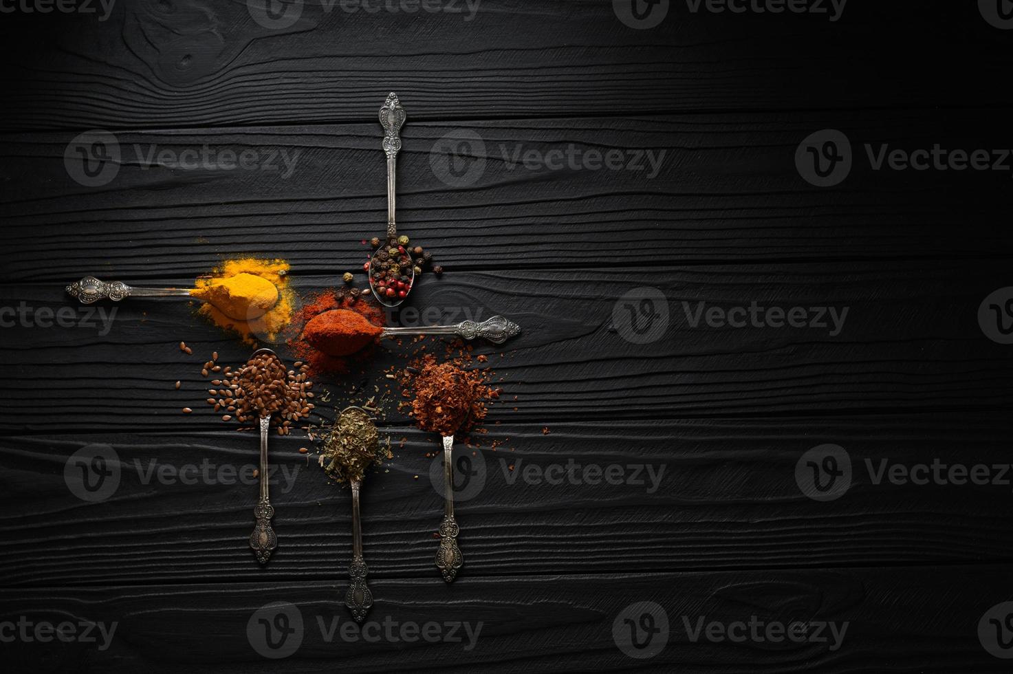 Colorful various herbs and spices for cooking on dark wooden rustic background photo