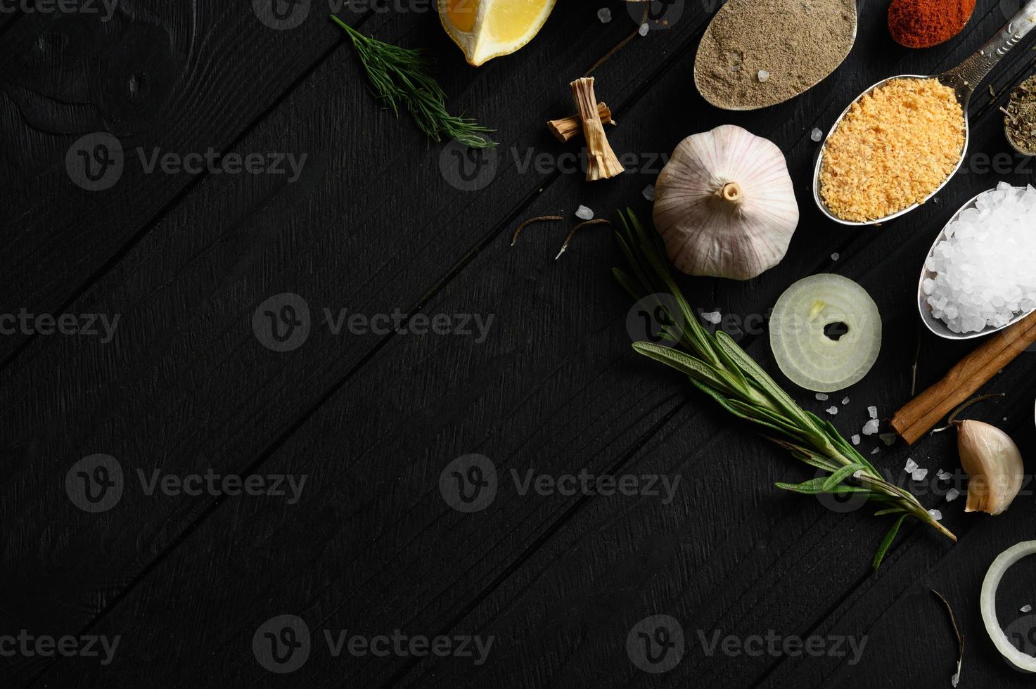 Colorful various herbs and spices for cooking on dark wooden rustic background photo
