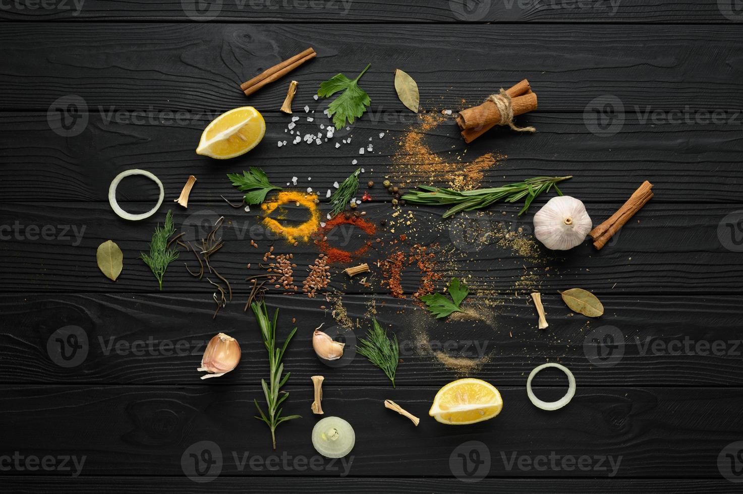 Colorful various herbs and spices for cooking on dark wooden rustic background photo