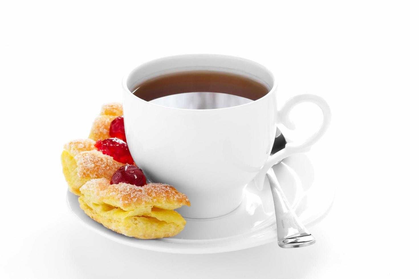 taza de té en un platillo y pastel. foto