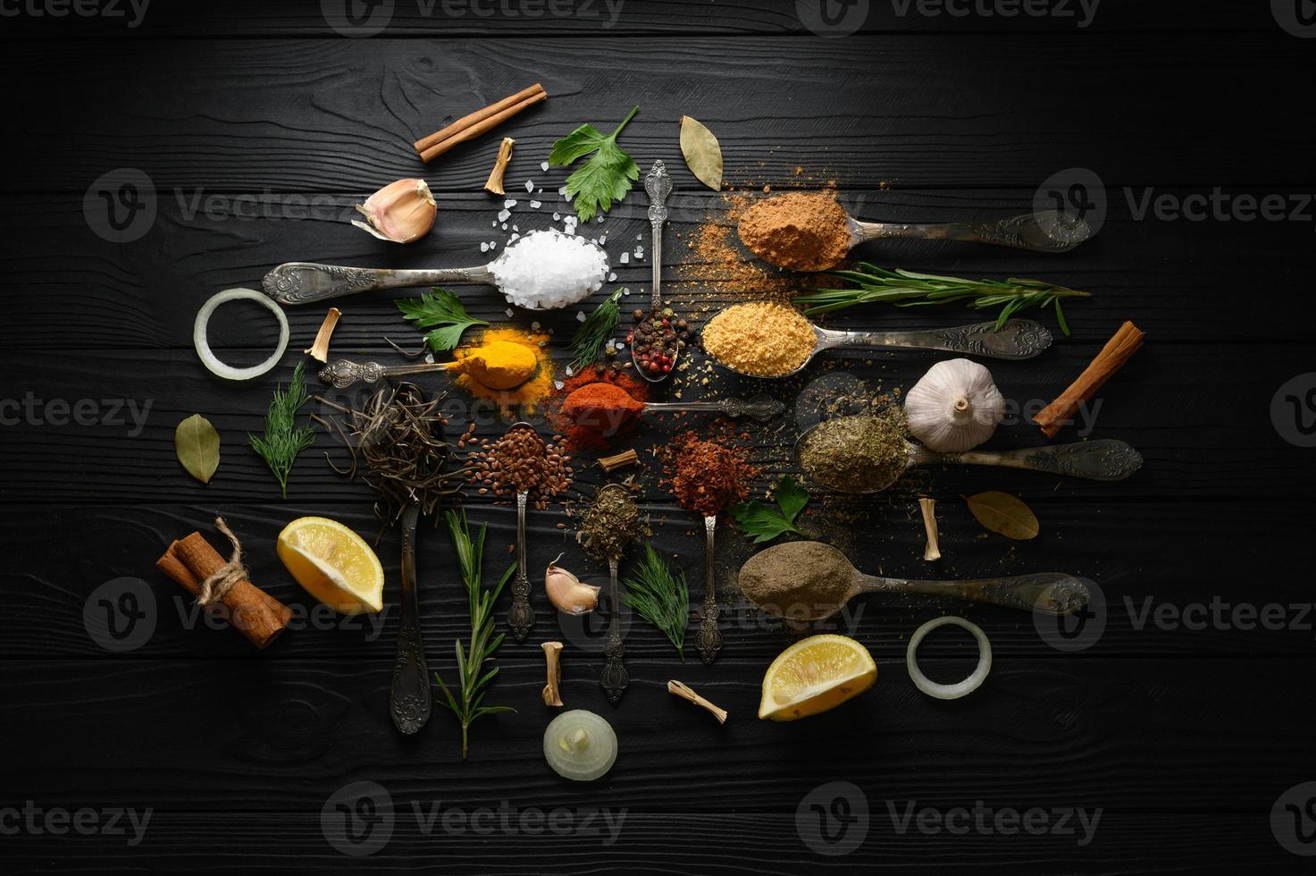 Colorful various herbs and spices for cooking on dark wooden rustic background photo