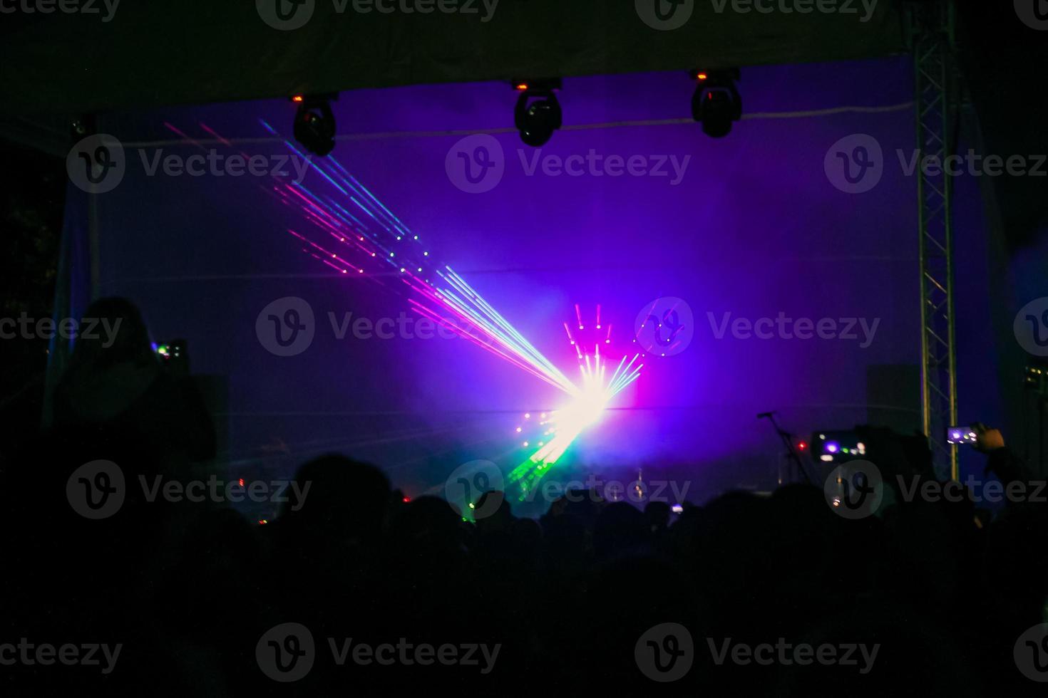Purple laser neon beams. Crowd of people watching laser show at street festival. photo
