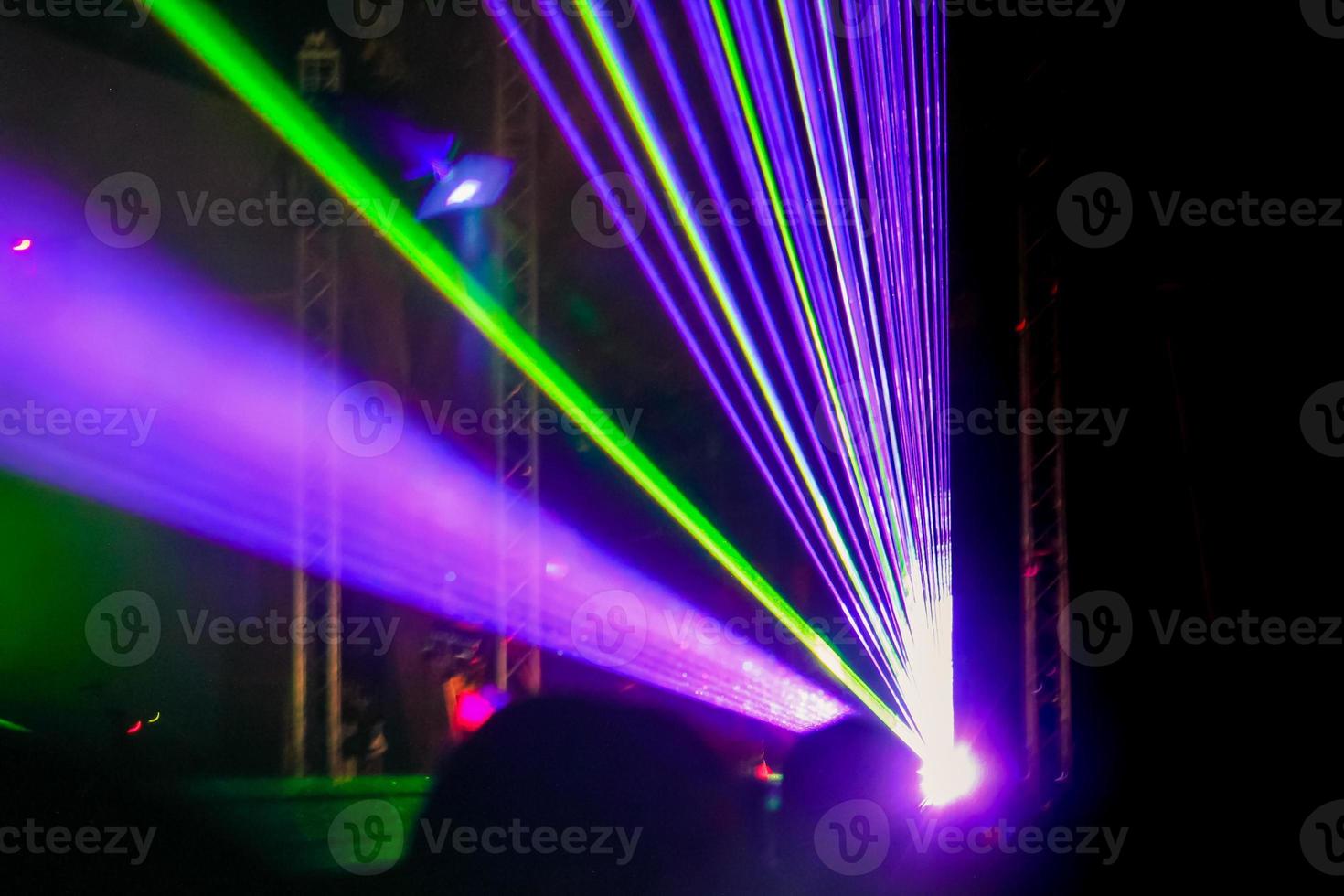 Purple laser neon beams. Crowd of people watching laser show at street festival. photo