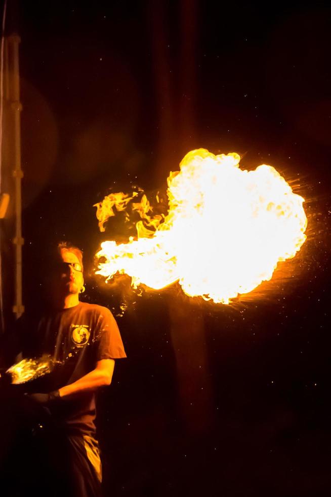 Fire show on the open air festival. Artists exhale flame, pillar of fire on a black background - July 8, 2015, Russia, Tver. photo