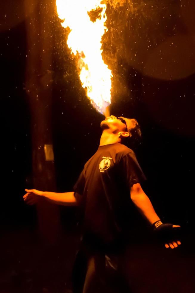 Fire show on the open air festival. Artists exhale flame, pillar of fire on a black background - July 8, 2015, Russia, Tver. photo