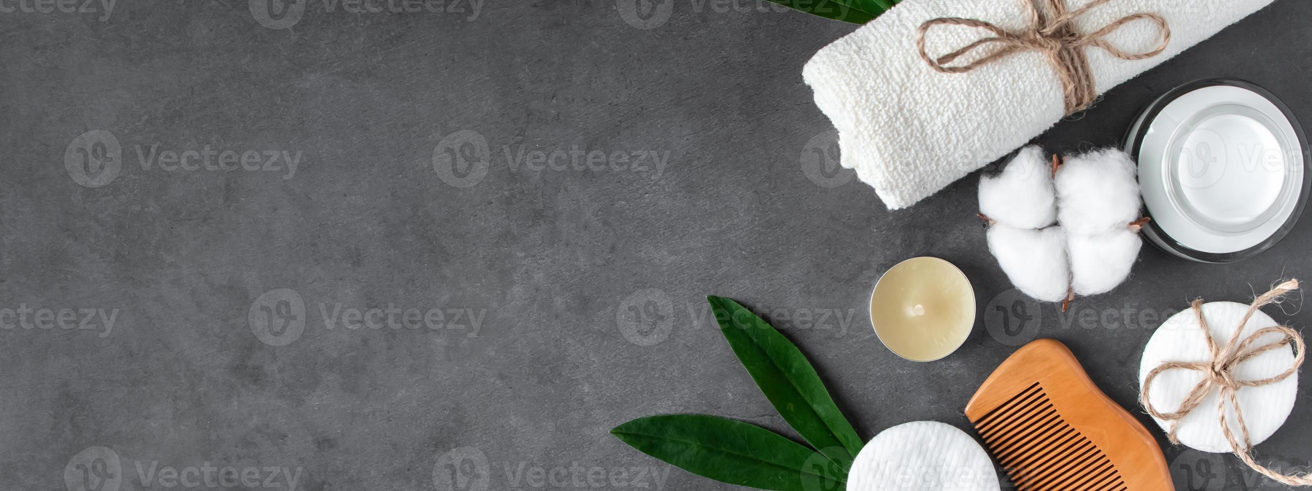Wellness and spa accessories on dark concrete background. Towel, hairbrush, candles and soap. photo
