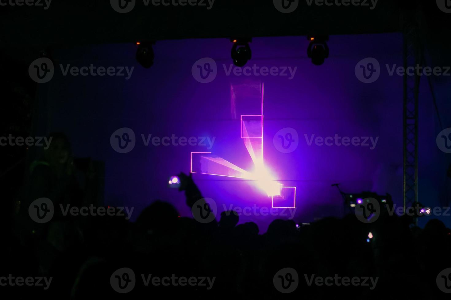 Purple laser neon beams. Crowd of people watching laser show at street festival. photo