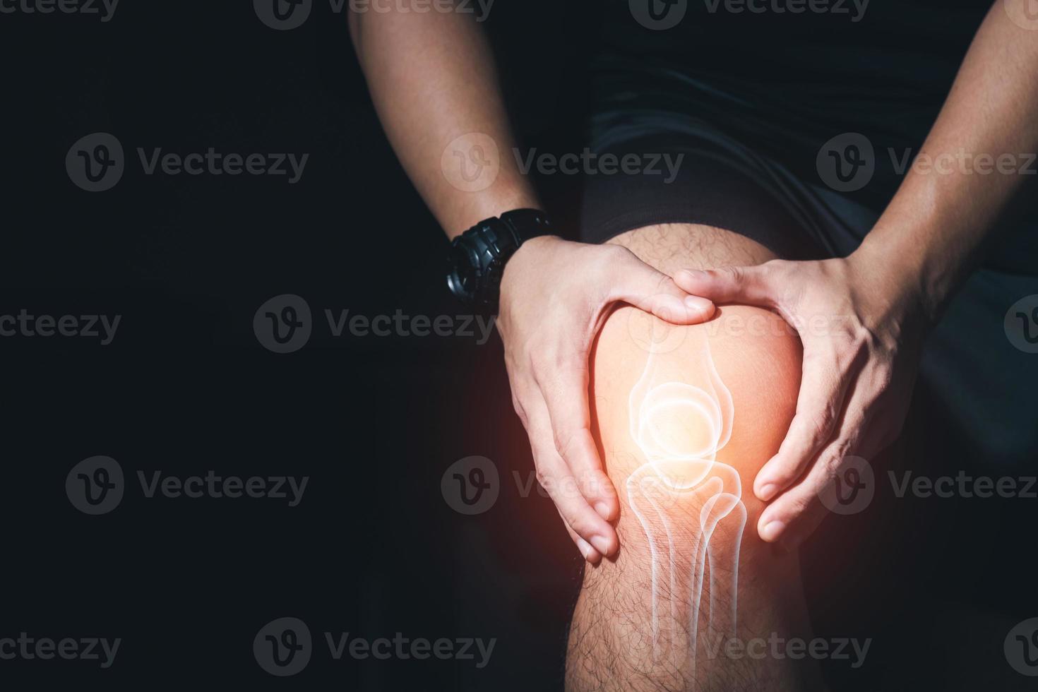 Young man with knee pain, joint pain, arthritis and tendon problems  exercise injury on dark background. photo