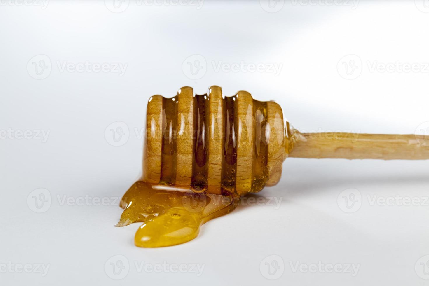 una cuchara para miel junto con miel de abeja de alta calidad foto