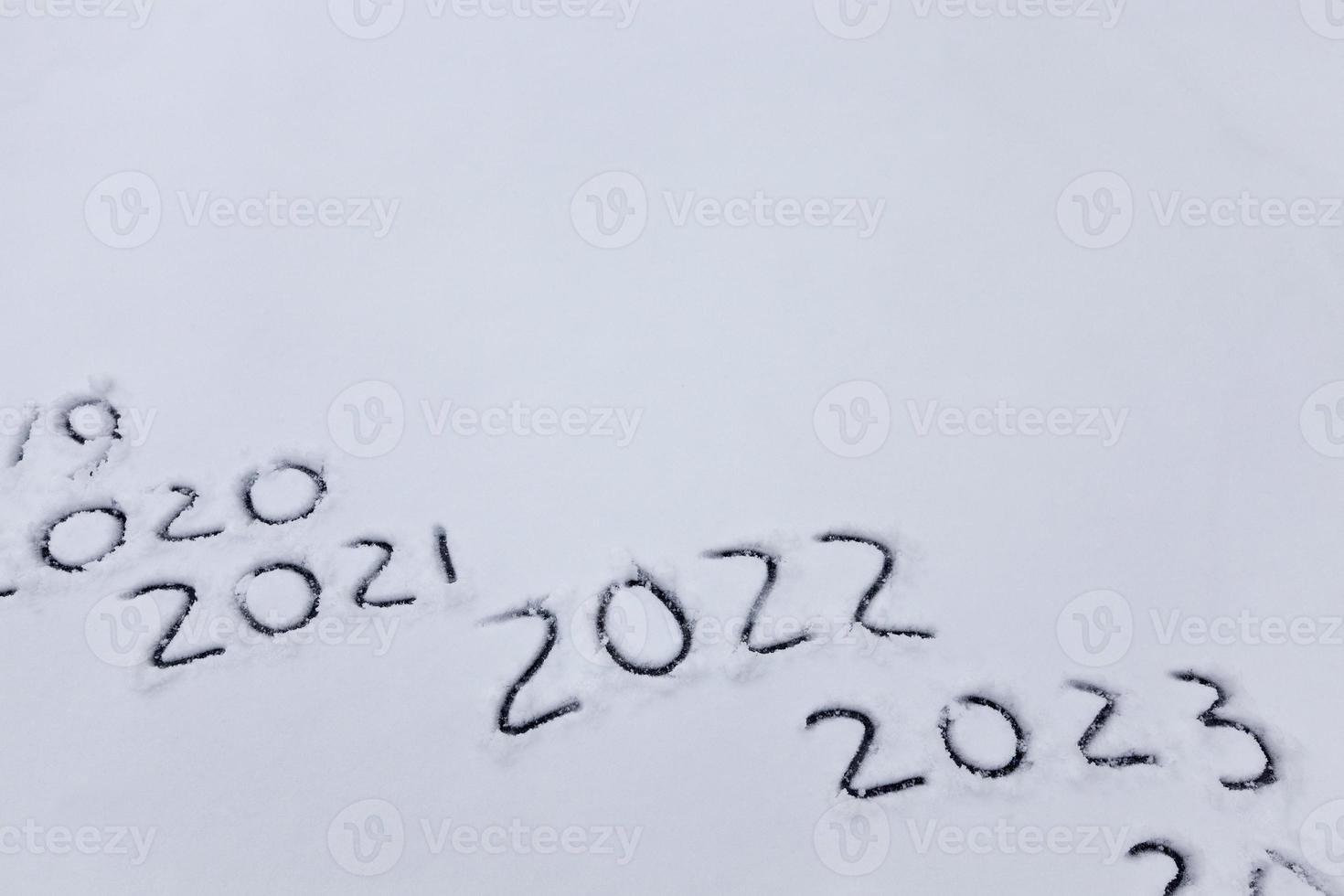 figures and the date of 2022 drawn on the snow photo