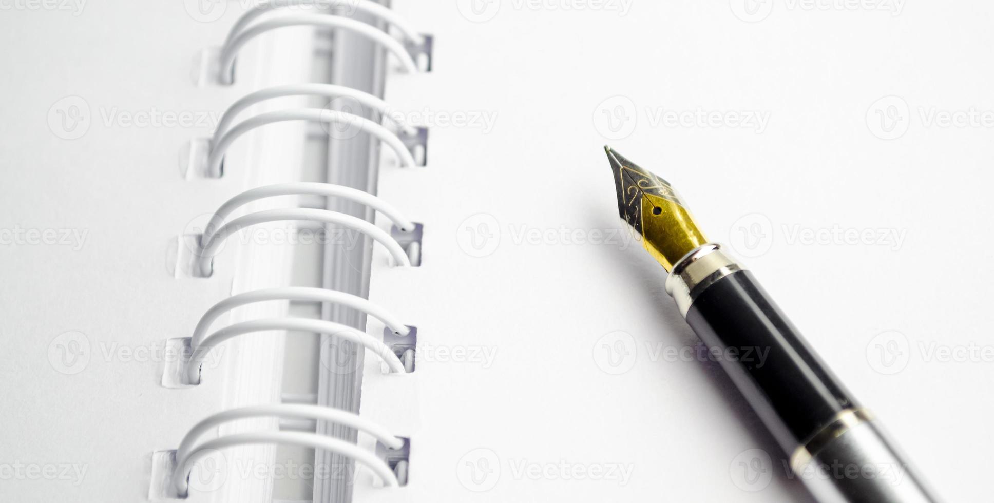 open notepad with pen on wooden background photo