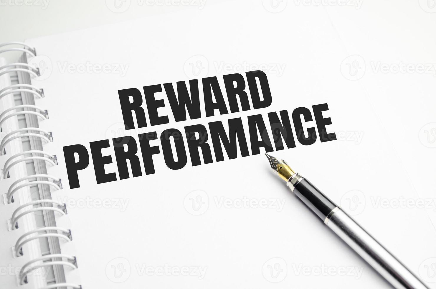 rEWARD PERFORMANCE text on paper with , pen with graph photo