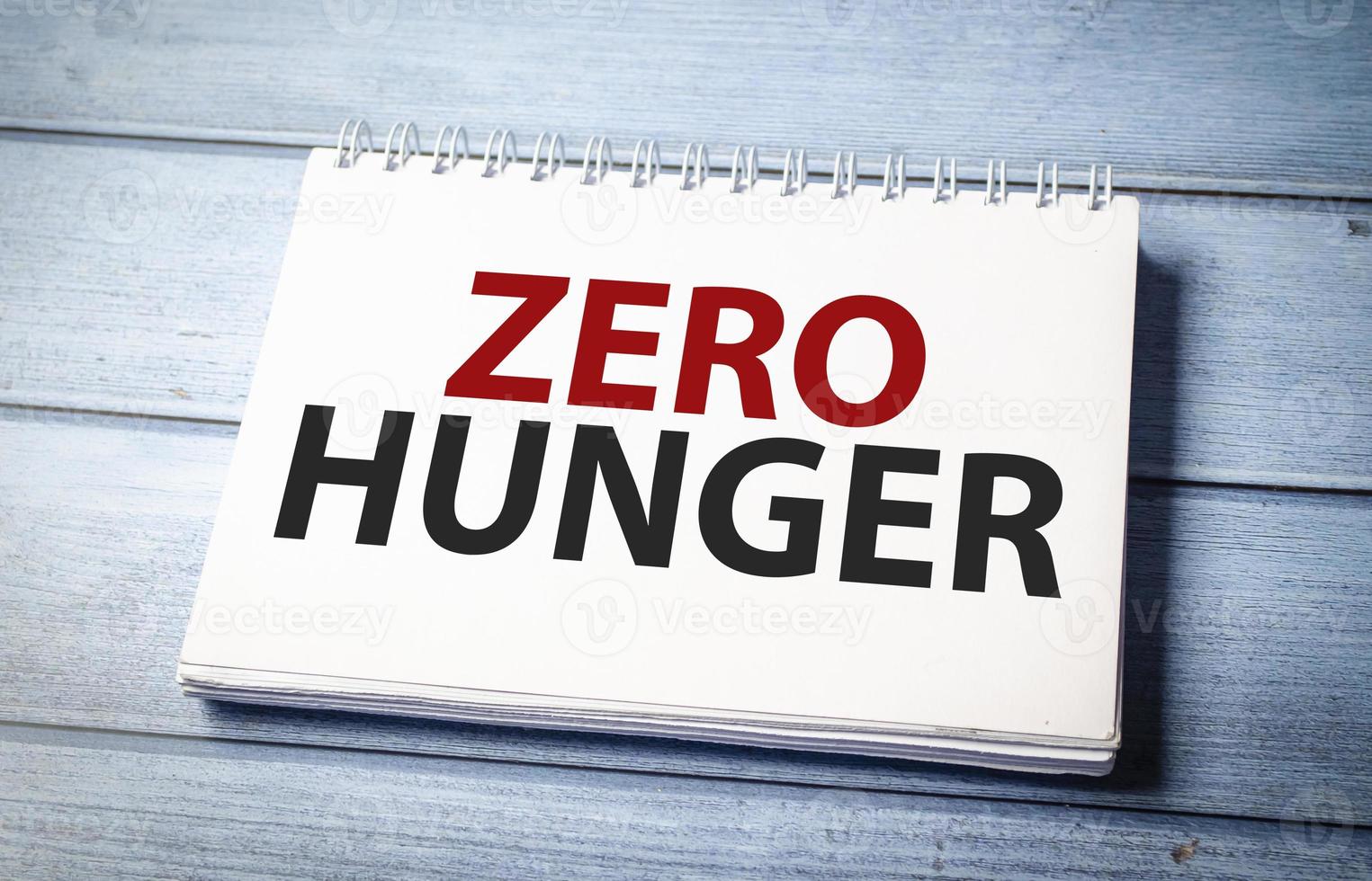 Zero hunger symbol on notepad and wooden background photo