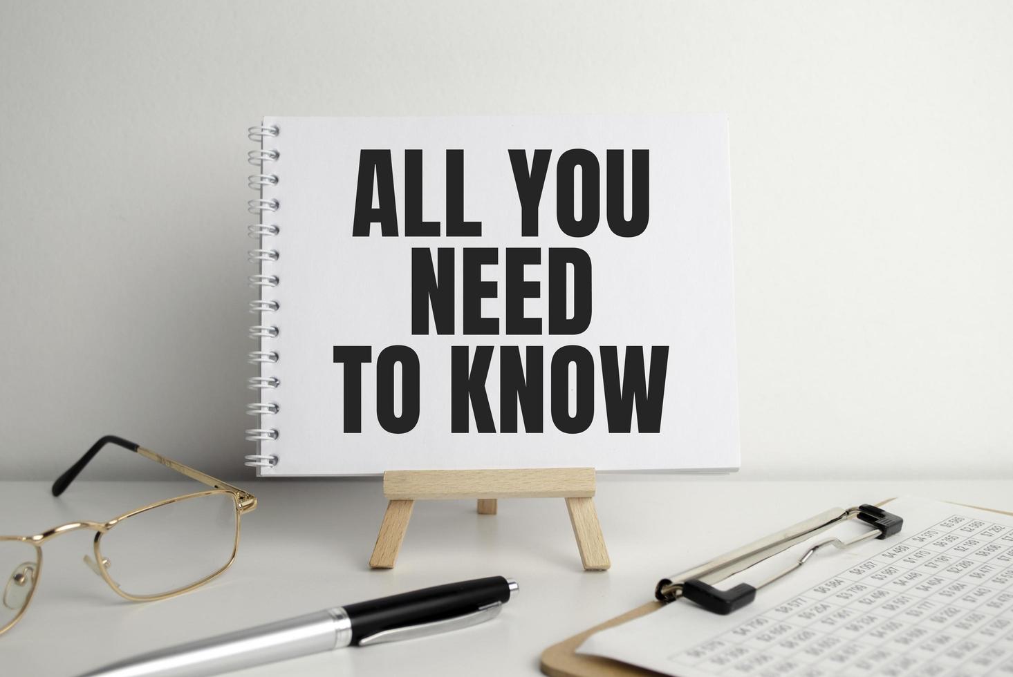 All you need to know, text on white paper on the light background with charts paper photo