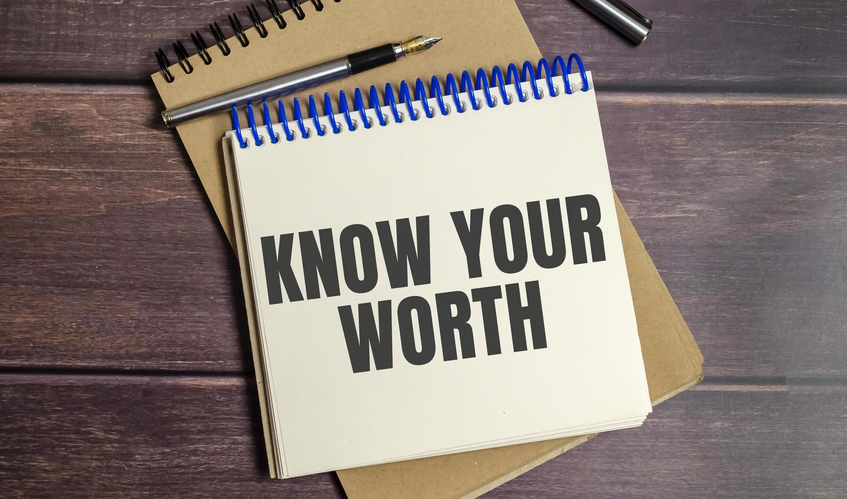 Know Your Worth words on notepad and wooden background photo