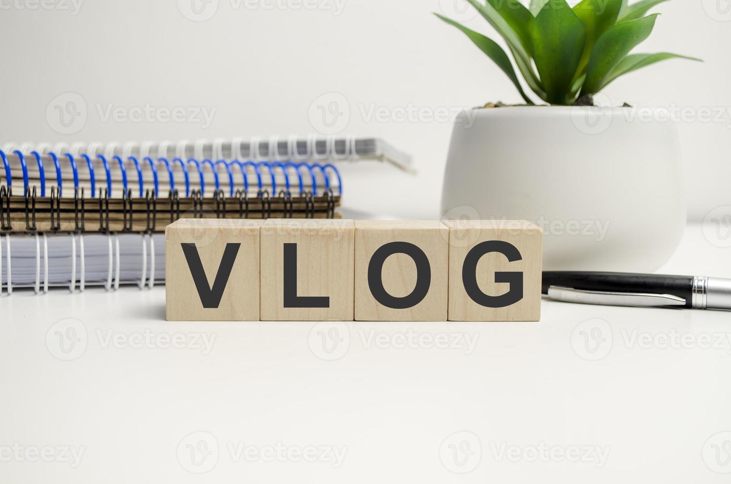 The word VLOG, spelt with wooden letter tiles over white background photo