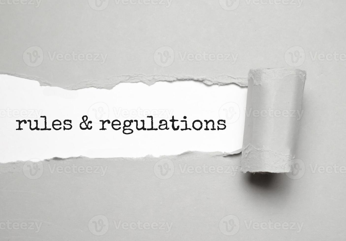 rules and regulations word under torn grey paper photo