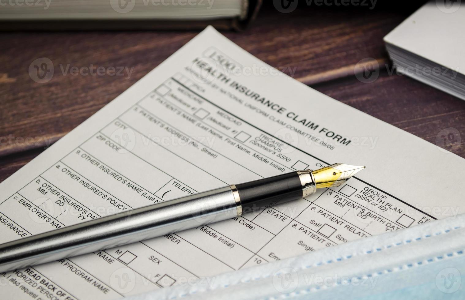 health insurance form with pen on wooden background photo