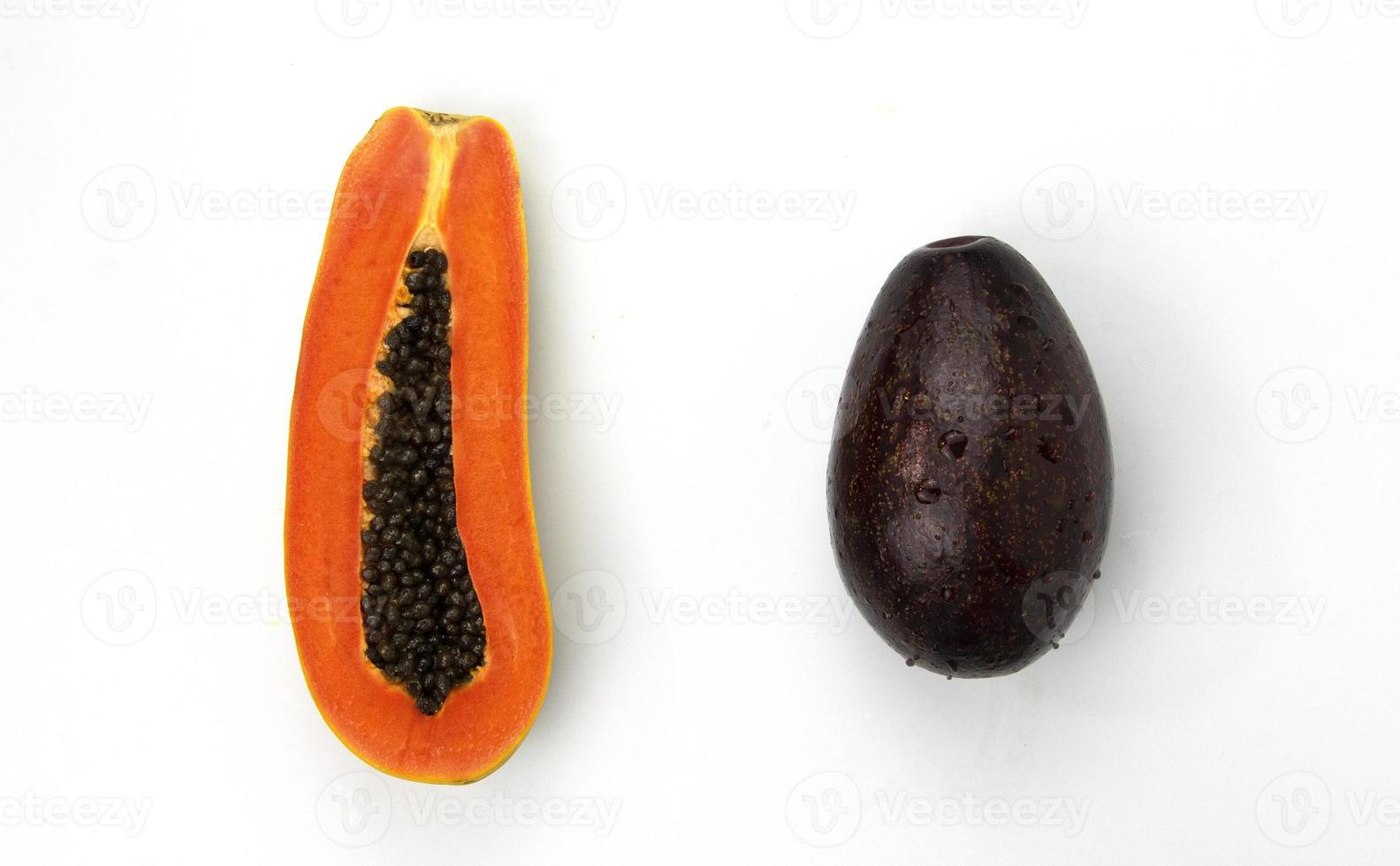 una papaya en rodajas y aguacate aislado sobre fondo blanco, frutas saludables, papaya, aguacate, utilizado para el diseño de conceptos de alimentos saludables foto