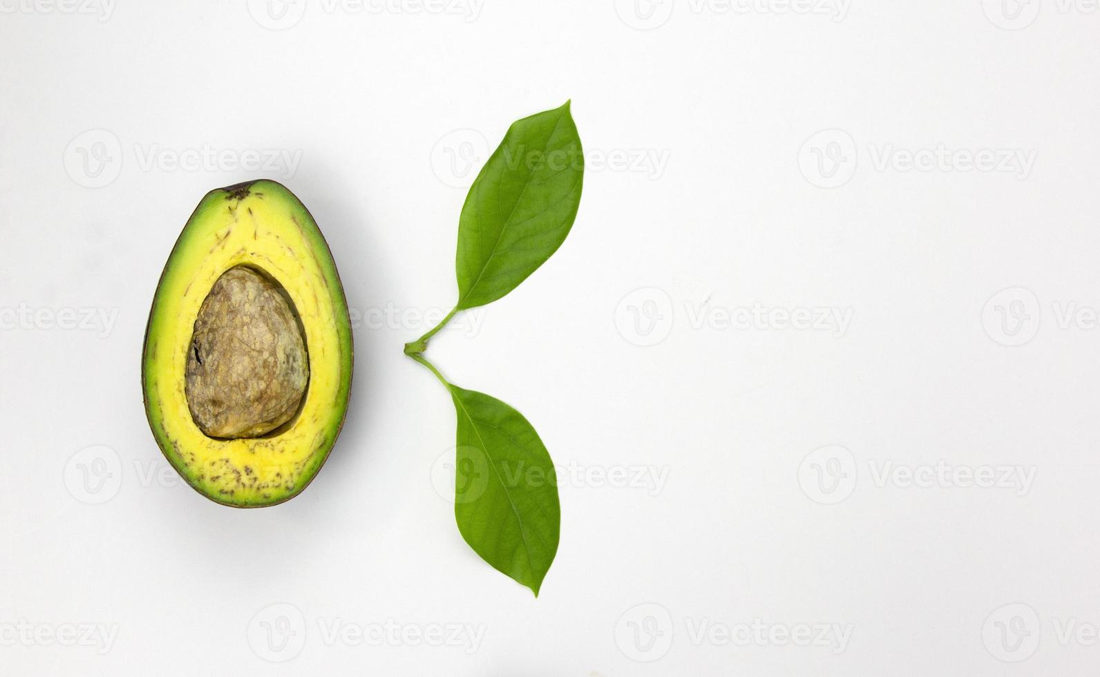 A half piece of Avocado fruit with green leaf isolated on white background, space for text description design, top view concept photo