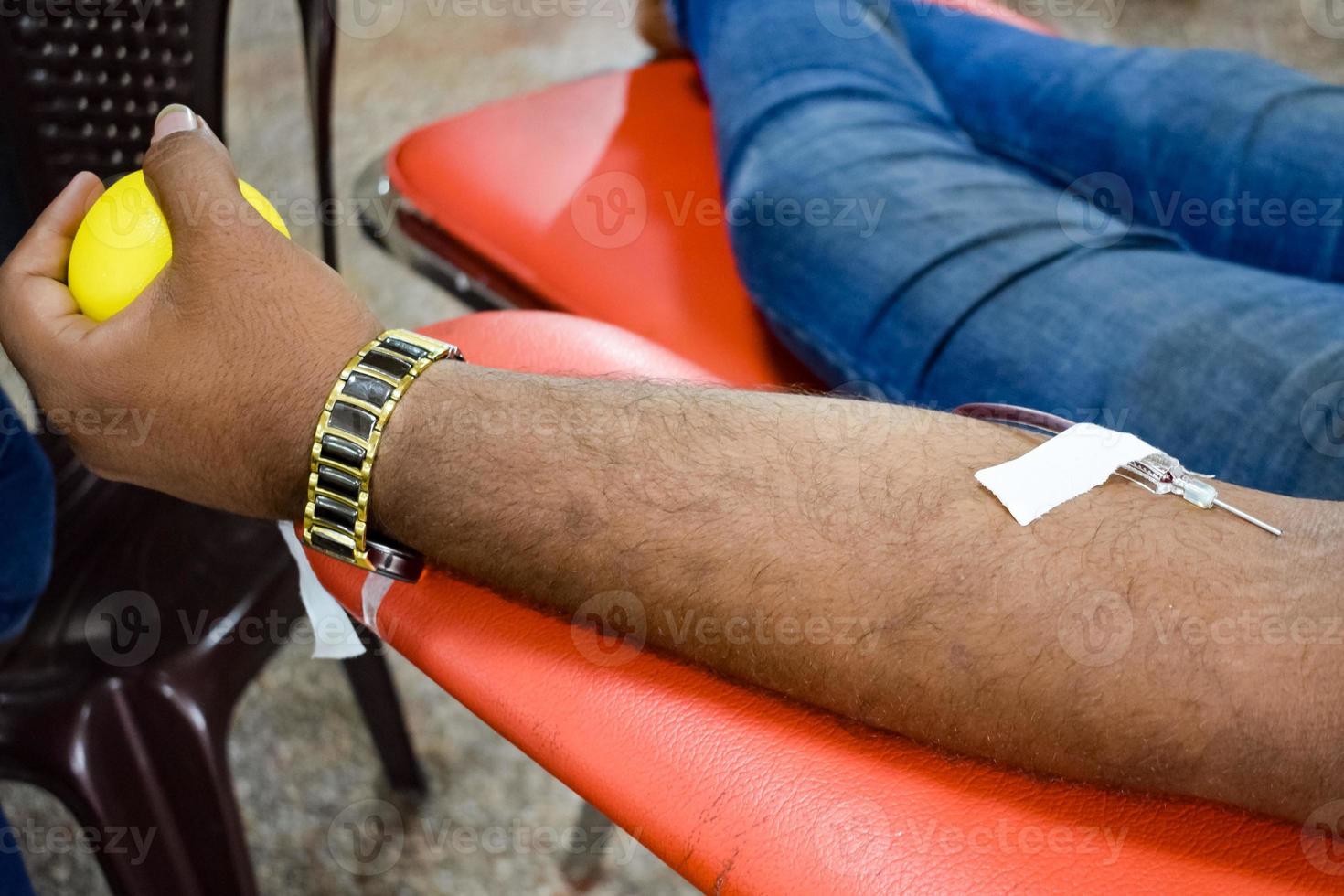 donante de sangre en el campamento de donación de sangre sostenido con una pelota hinchable en la mano en el templo balaji, vivek vihar, delhi, india, imagen para el día mundial del donante de sangre el 14 de junio de cada año, campamento de donación de sangre foto