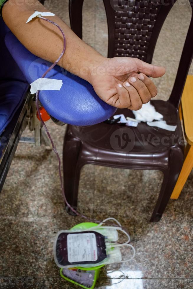 Blood donor at Blood donation camp held with a bouncy ball holding in hand at Balaji Temple, Vivek Vihar, Delhi, India, Image for World blood donor day on June 14 every year, Blood Donation Camp photo