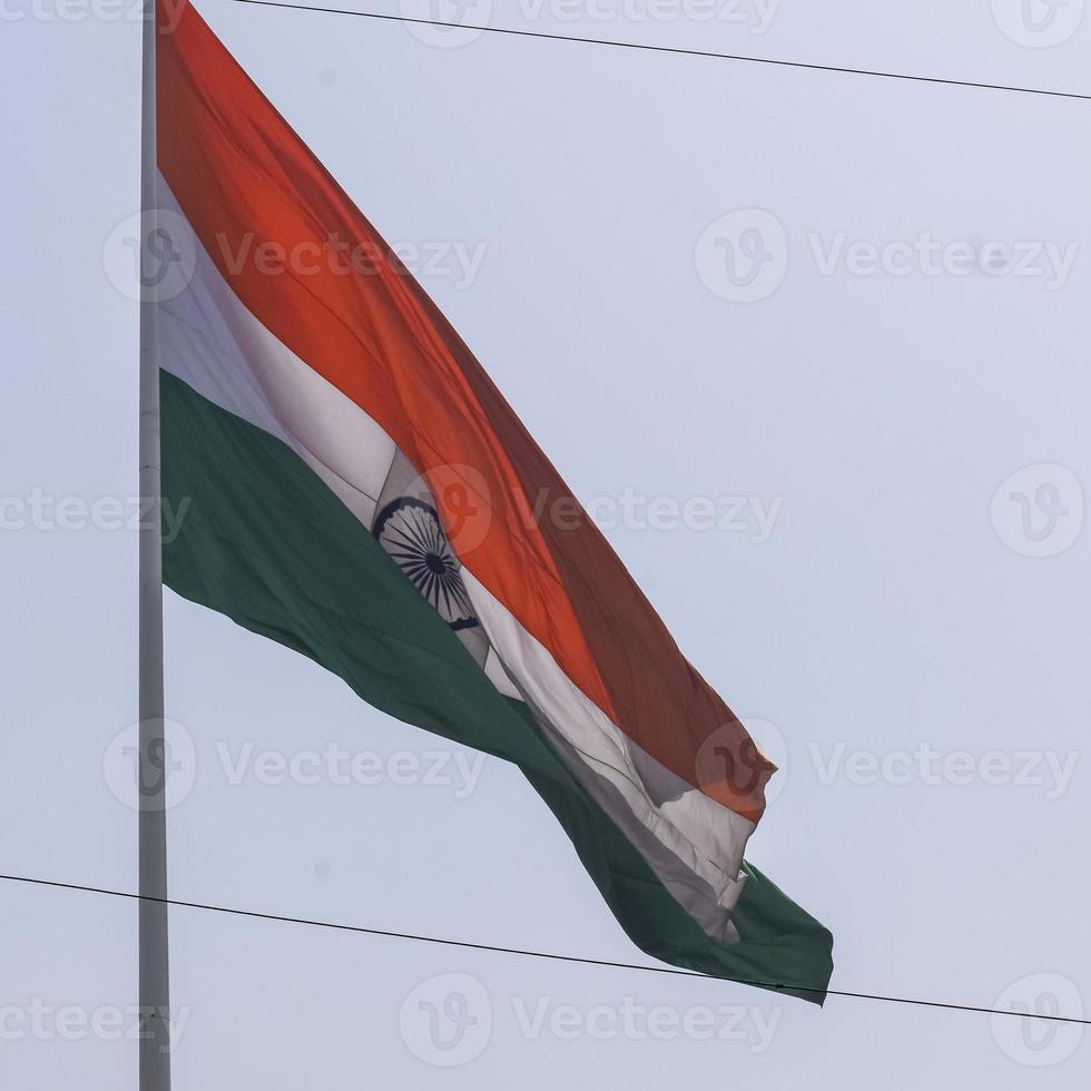 India flag flying high at Connaught Place with pride in blue sky, India flag fluttering, Indian Flag on Independence Day and Republic Day of India, tilt up shot, waving Indian flag, Flying India flags photo