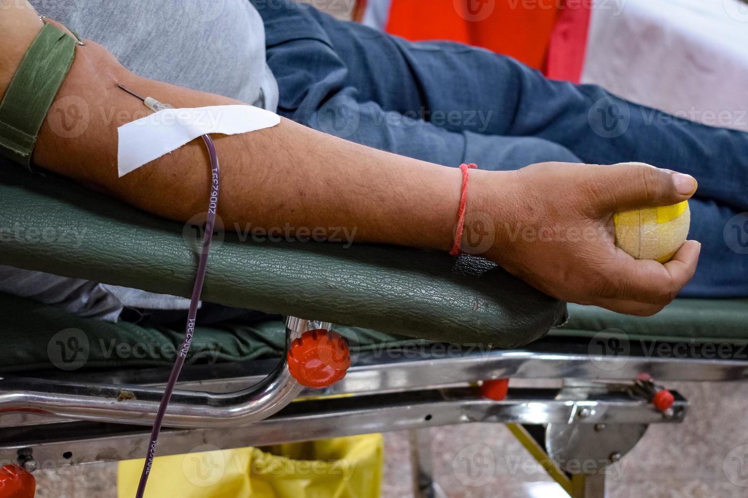 Blood donor at Blood donation camp held with a bouncy ball holding in hand at Balaji Temple, Vivek Vihar, Delhi, India, Image for World blood donor day on June 14 every year, Blood Donation Camp photo