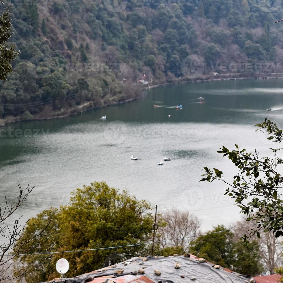 Full view of Naini Lake during evening time near Mall Road in Nainital, Uttarakhand, India, Beautiful view of Nainital Lake with mountains and blue sky photo