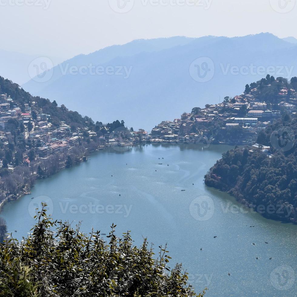 Full view of Naini Lake during evening time near Mall Road in Nainital, Uttarakhand, India, Beautiful view of Nainital Lake with mountains and blue sky photo