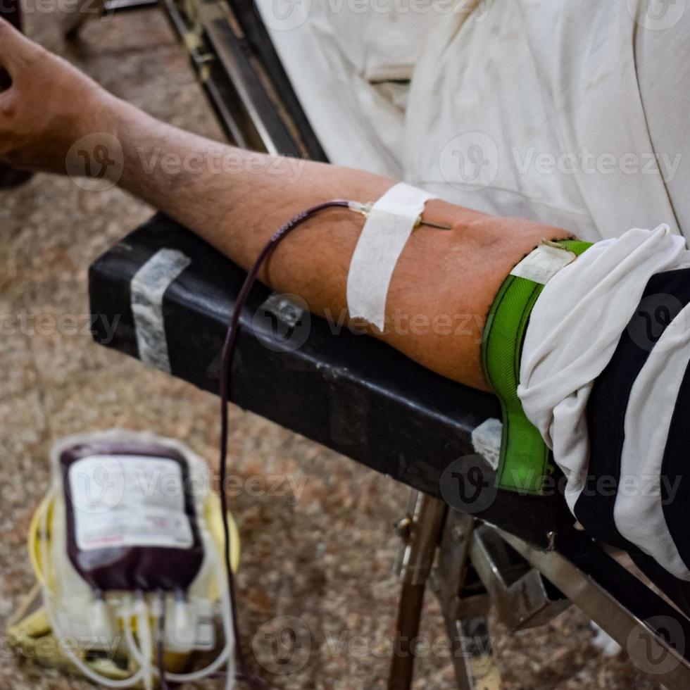 Blood donor at Blood donation camp held with a bouncy ball holding in hand at Balaji Temple, Vivek Vihar, Delhi, India, Image for World blood donor day on June 14 every year, Blood Donation Camp photo