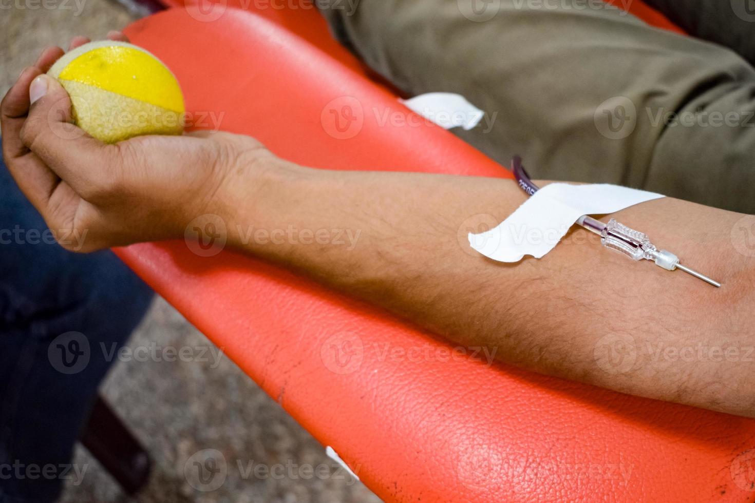 donante de sangre en el campamento de donación de sangre sostenido con una pelota hinchable en la mano en el templo balaji, vivek vihar, delhi, india, imagen para el día mundial del donante de sangre el 14 de junio de cada año, campamento de donación de sangre foto